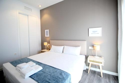 马拉加Del Parque Flats Urban Relax的卧室配有白色的床和2条毛巾