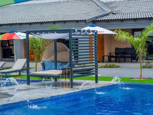路易特里哈特The Lux Hotel and Resorts的一个带遮阳伞、椅子和桌子的游泳池