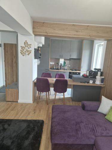 布拉索夫Casa Mov的一间带紫色沙发的客厅和一间厨房