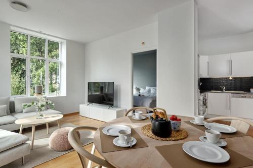 卑尔根Lys & luksuriøs leilighet midt i Bergen sentrum!的厨房以及带桌椅的起居室。