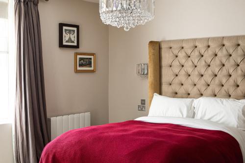 Nailsea贝克韦尔乔治宾馆的一间卧室配有一张带红色毯子的大床