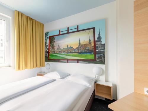 德累斯顿德累斯顿住宿加早餐酒店的卧室配有白色的床和墙上的绘画作品