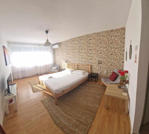 克拉约瓦Sunny Place Garsoniera -posibilitate self check in的一间卧室设有一张床和砖墙