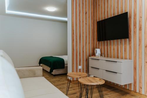 维尔蒂尼克Vila K2的一间设有床铺和墙上电视的房间