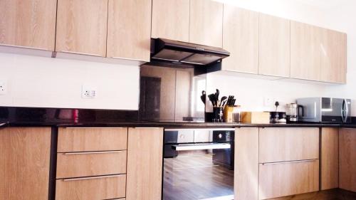 斯科特堡The Donga House - Luxury Home near Scottburgh Beach的厨房配有木制橱柜和炉灶烤箱。