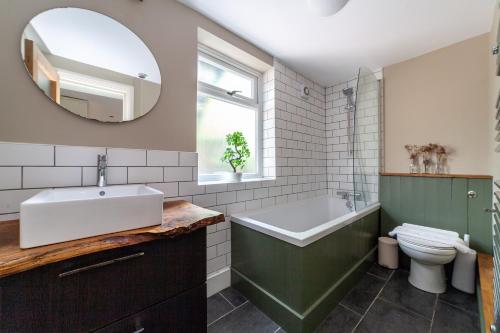 伦敦The Finsbury Park Collection的一间带水槽、浴缸和卫生间的浴室