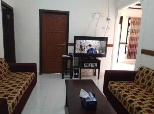BajawaMawar Bed and Breakfast的客厅配有两张沙发和一台电视