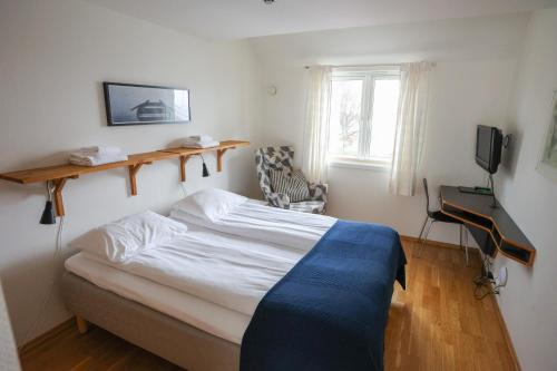 Østhusvik布利斯峡湾酒店的一间卧室配有一张床、一张书桌和一台电视