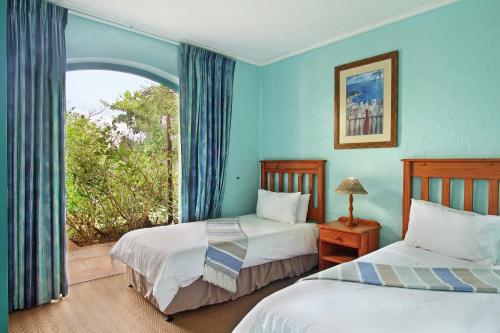 爱德华港Caribbean Estates Holiday Resort的带窗户的客房内的两张床
