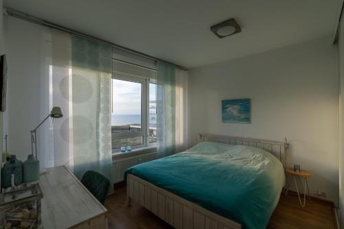 海边的艾格蒙特Appartement Majelle的一间卧室设有一张床和一个大窗户