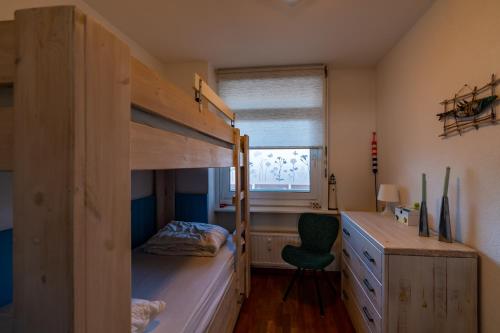 海边的艾格蒙特Appartement Majelle的一间卧室配有双层床和书桌
