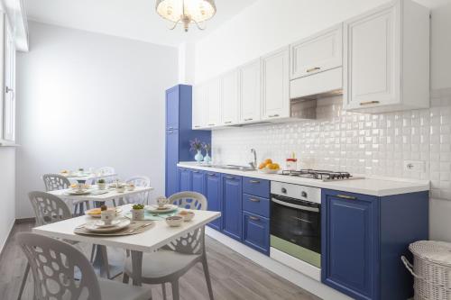 加利波利Costa Azzurra Gallipoli的厨房配有蓝色橱柜和桌椅