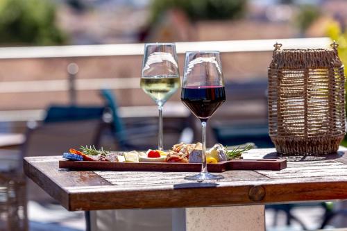 阿卡雄Best Western Arcachon Le Port的一张桌子,上面放着两杯葡萄酒和一盘食物
