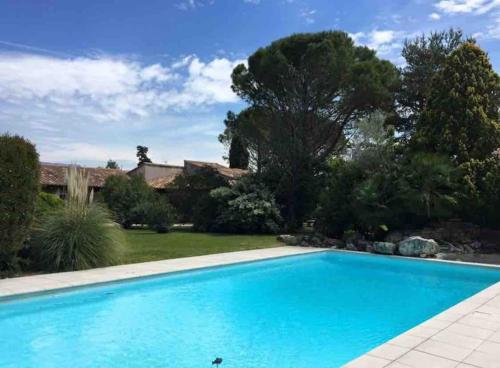 蒙特利马尔La Villa del Sol的一座带房子的庭院内的游泳池