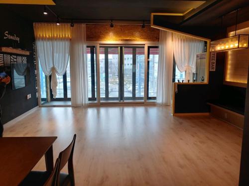 清州市T stay pension的大型客房,设有木地板和窗户。