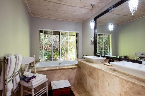 钦查普拉纳旅舍的带浴缸、水槽和镜子的浴室