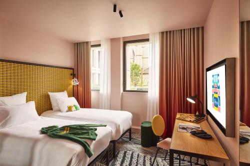 第戎Mama Shelter Dijon的酒店客房设有两张床和一台平面电视。
