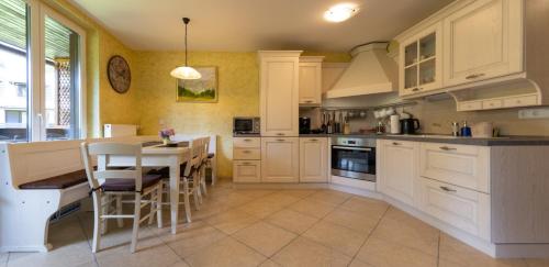戈雷尼斯卡地区采尔克列Apartma Krvavec的厨房配有白色橱柜和桌椅