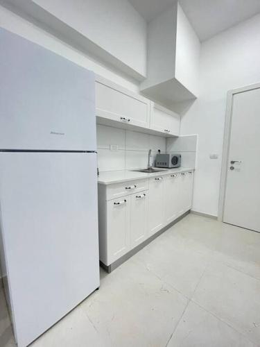 内坦亚Zan的厨房配有白色橱柜和白色冰箱。