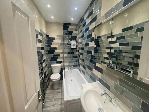伦敦Charming 5 Bed - Leytonstone E11的带浴缸、卫生间和盥洗盆的浴室