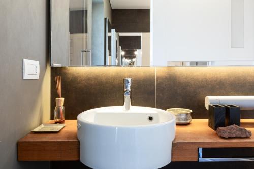 米兰Città Studi Terrace Suite with Jacuzzi - Top Collection的木制柜台上带白色水槽的浴室