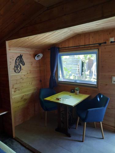WapenveldB&B Paardenhof的小房间设有桌子、两把椅子和窗户