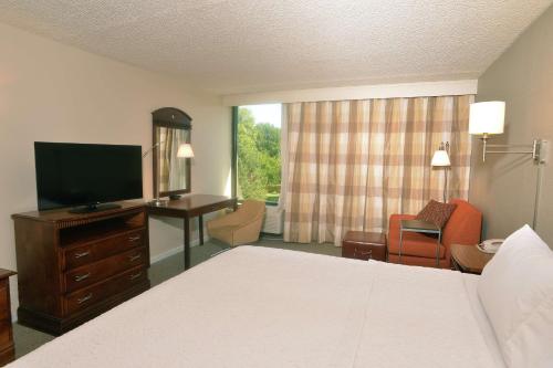 斯普林菲尔德Hampton Inn Springfield-South的酒店客房配有一张床、一张书桌和一台电视。