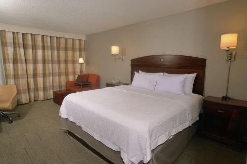 斯普林菲尔德Hampton Inn Springfield-South的酒店客房带一张大床和一把椅子