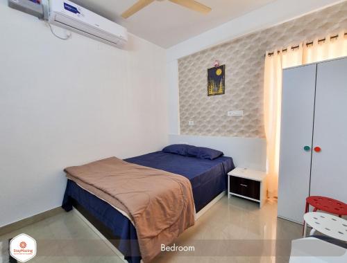 班加罗尔StayMazing Boutique AC Apartments-Manyata,Hebbal-1,2&3 BHKs-30mins to Airport的一间卧室设有一张床、一个窗口和风扇