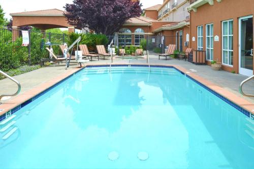 纳帕纳帕希尔顿花园酒店的大楼前的大型蓝色游泳池