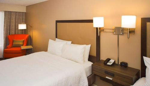 瓦尔多斯塔瓦尔多斯塔/会议中心汉普顿旅馆及套房酒店的一间酒店客房,配有一张床铺和一张桌子上的电话