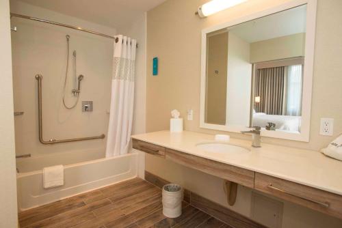桑德贝桑德贝希尔顿恒庭套房酒店的一间带水槽、淋浴和镜子的浴室