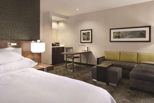 匹兹堡匹兹堡市中心希尔顿合博套房酒店的配有一张床和一张书桌的酒店客房