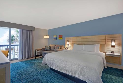 杰克逊维尔海滩杰克逊维尔海滩汉普顿酒店的酒店客房设有一张大床和一个阳台。