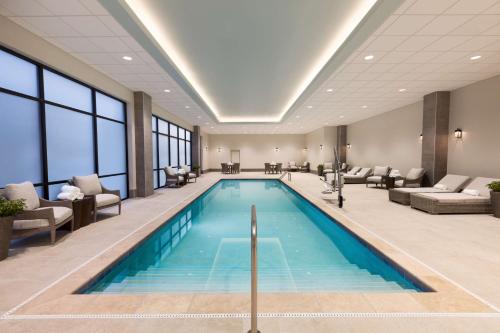 威尔明顿Embassy Suites By Hilton Wilmington Riverfront的酒店大堂的游泳池,有等候室