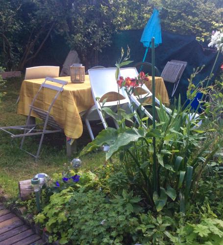 洛里昂Maison Lorient Sud的花园里种满鲜花,配有桌椅