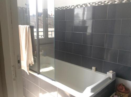 洛里昂Maison Lorient Sud的带浴缸和玻璃淋浴间的浴室。
