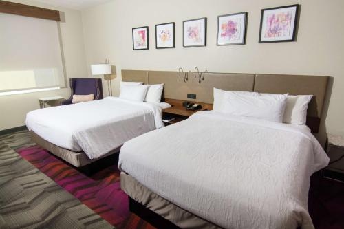 鲁兹Hilton Garden Inn Tampa Suncoast Parkway的酒店客房,配有两张带白色床单的床
