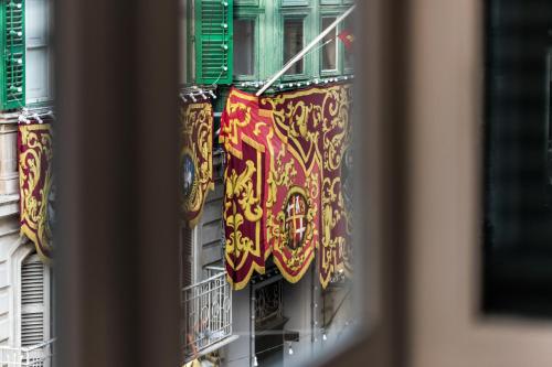 瓦莱塔多莫斯扎米特罗酒店的建筑物上带有彩色旗帜的窗口