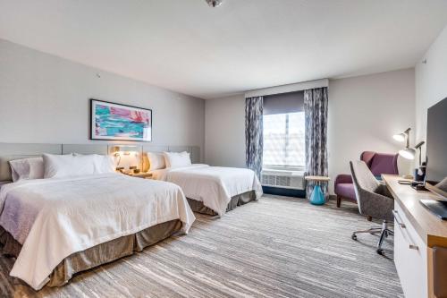 达拉斯Hilton Garden Inn Dallas-Central Expy/North Park Area, Tx的酒店客房配有两张床和一张书桌