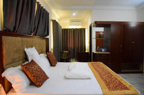 WaDellagio Hotel的卧室配有带棕色枕头的大型白色床