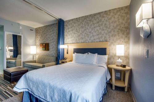 欧文Home2 Suites by Hilton DFW Airport South Irving的酒店客房带一张大床和一把椅子