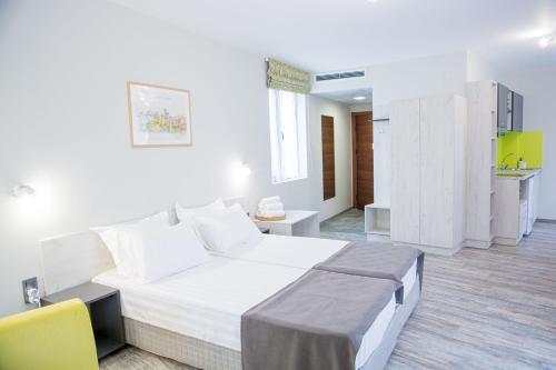 舒门Arima city的卧室配有一张白色大床和一张黄色椅子