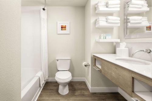 乔治敦乔治敦码头希尔顿恒庭酒店的白色的浴室设有卫生间和水槽。