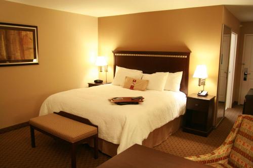 托皮卡托皮卡汉普顿酒店的酒店客房设有一张大床,上面有托盘