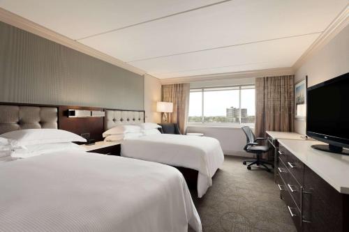 费城费城城市大道希尔顿酒店的酒店客房设有两张床和一台平面电视。
