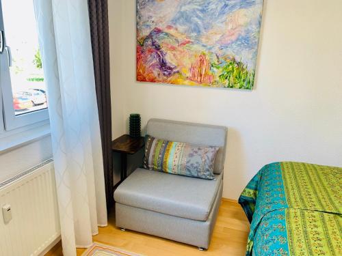 卡尔斯鲁厄AnNa Home & Sunny Home Apartments的卧室配有椅子和墙上的绘画