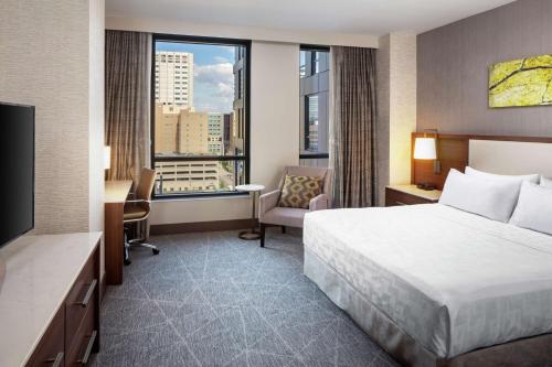 罗切斯特Hilton Rochester Mayo Clinic Area的酒店客房设有一张床和一个大窗户