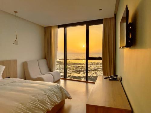 杰迪代Les Roches De Mazagan的一间卧室配有一张床,享有海景