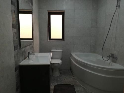 彭布罗克Large 3 Bedroom Apartment的带浴缸、卫生间和盥洗盆的浴室